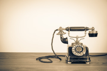 Old retro telephone on table. Vintage style sepia photo