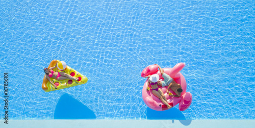 Aerial Close Up Beautiful Couple And Fit Girl Lying On Fun Colorful Inflatable Floaties