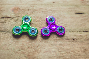 Colored fidget spinners stress relieving toy on wooden background