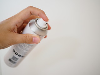 Left hand holding spray bottle, white background