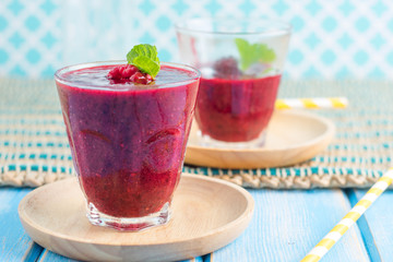 Berry Smoothie with Mint, black currant, red currant, raspberry and blueberry on blue wooden table