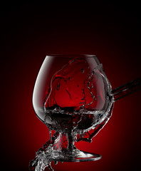 Fototapeta na wymiar Cognac glass with splash