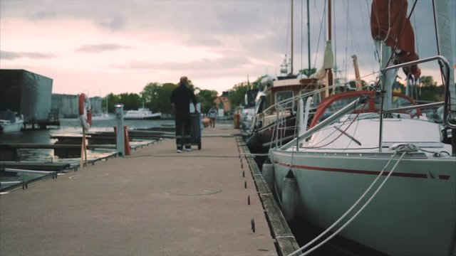 Yachts and boats in old port in mediterranean sea, sunset, man pushes dolly