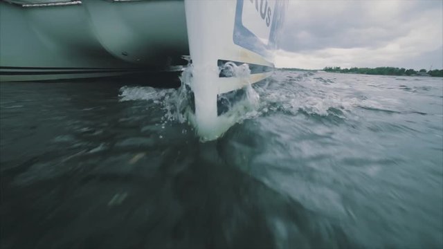 Close up on the bow of a sailing yacht breaking through a wave