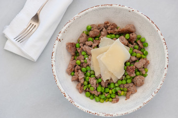Fresh cooked meal with sausages, peas and parmesan