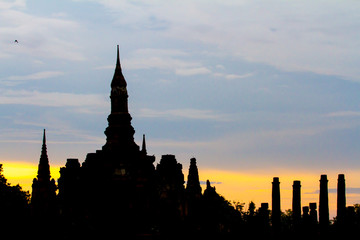 Naklejka premium Sukhothai Historical Park with sihouette sunset in Thailand. Famous historical park in Thailand. Sunset at the park.
