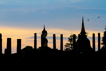 Naklejka premium Sukhothai Historical Park with sihouette sunset in Thailand. Famous historical park in Thailand. Sunset at the park.