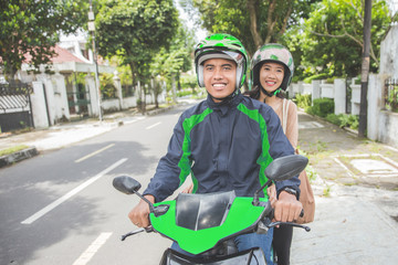 commercial motorcycle taxi driver taking his passenger to her destination