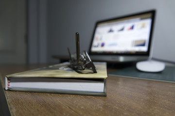 Glasses on a book in front of laptop with low light in room. Concept : relaxing, business and library.