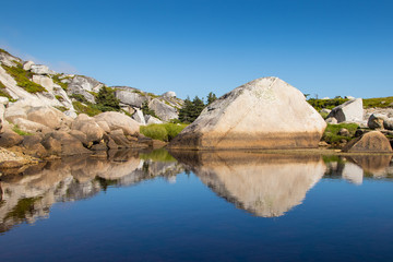 A small inlet right on the ocean in Nova Scotia.  It is mirror calm here and the waves are crashing only meters away.