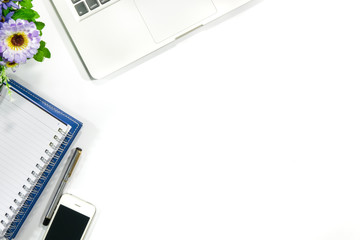 Modern white office desk table with laptop, smartphone notebook and other supplies on white table background. Top view, flat lay. Concept for business, and Modern office.