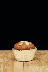 Banana cupcake, very yummy and delicious banana cake and almond toping on the wood table with free space.