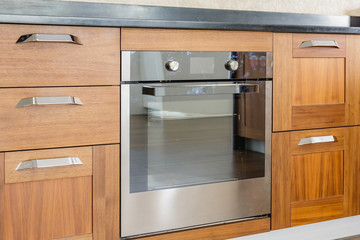 Kitchen cabinets with metal handles and built-in electric oven