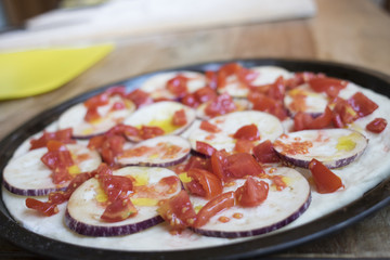 preparing vegetarian pizza with eggplants and tomatoes