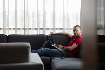 Obraz premium Man using laptop in living room