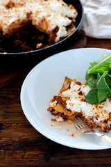 homemade lasagne served in a plate with salad