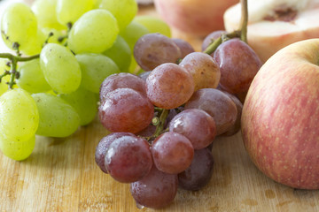 Peaches, apple and grapes on the wooden table. Closeup. Fresh and delicious fruits.