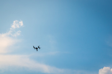 Drone hovering in a bright blue sky