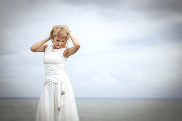 Fototapeta na wymiar woman in white dress on the seashore