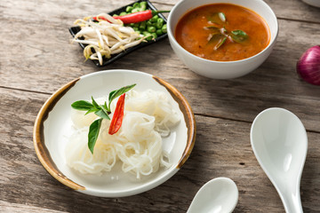 Noodle and fish curry sauce with ingredient on black table.