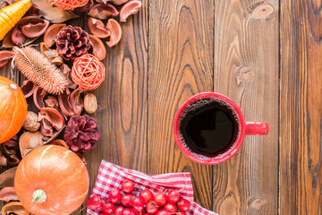 red cup of tea on wooden table, autumn decor, sackcloth, pumpkins, fruits, top view