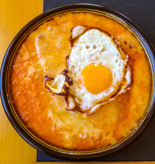 The signature dish: Isolated Melting Cheese with egg and bread. Perfect to share with your family and friends on a cold evening, a winter meal you can start but never stop.