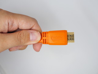 Left hand holding orange small USB connector