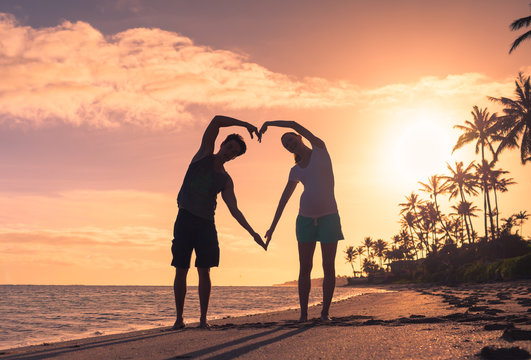 People In Love. Couple On The Beach Making Heart Shape. 