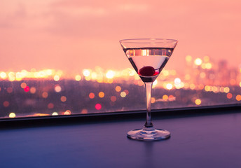 Martini alcoholic drink and city lights. Night life concept. 
