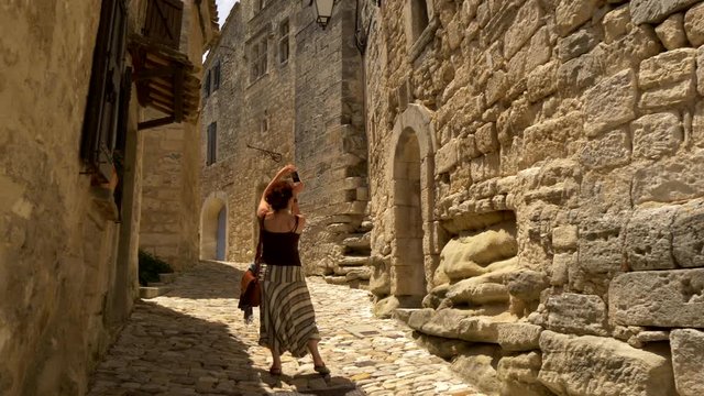 Tourist woman taking photo of Lacoste ancient village. Provence, France