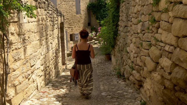 Tourist woman walking and taking photo of ancient European village