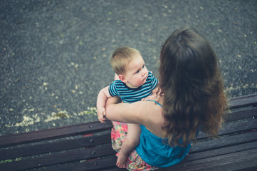 Mother with baby on park bench