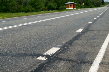 Asphalt road and single pavilion.
The canvas road with the roadside goes into the distance, where you see a lonely orange booth.