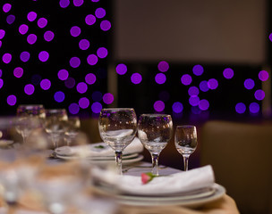 Beautiful table setting with crockery and flowers for a party, wedding reception or other festive event. Glassware and cutlery for catered event dinner.