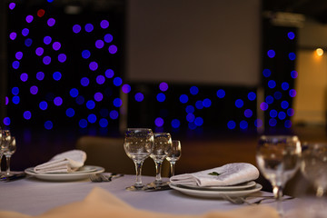 Beautiful table setting with crockery and flowers for a party, wedding reception or other festive event. Glassware and cutlery for catered event dinner.