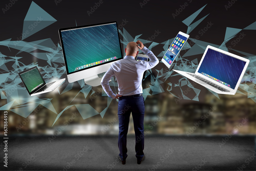 Poster businessman in front of a wall with computer and devices displayed on a futuristic interface with in