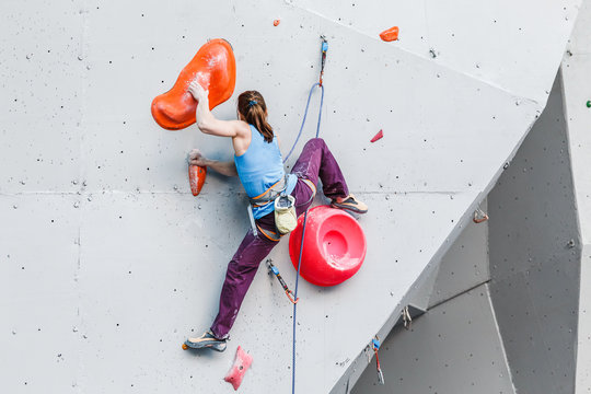 active young and fit woman on artificial climbing rock wall in extreme sport center