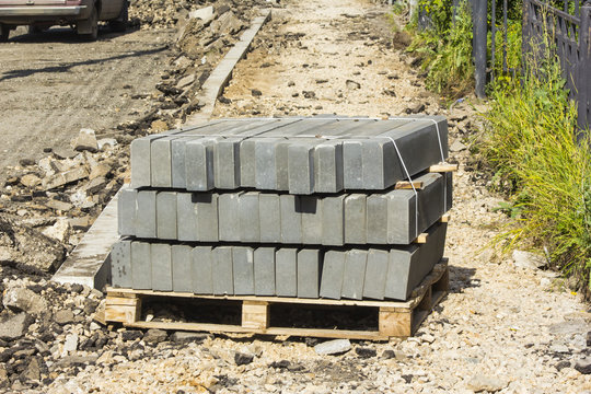 Repair of the road. Curbs on the pallet near the road