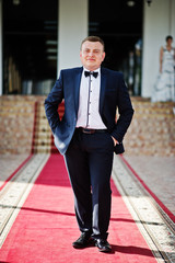Portrait of an intelligent and handsome young man dressed in tuxedo posing on the red carpet. © AS Photo Family