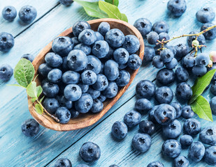 Blueberries in the wooden bowl on the table.