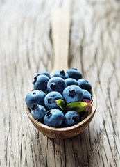 Blueberries in the wooden spoon on the table.