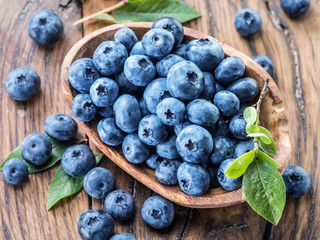 Blueberries in the wooden bowl on the table.
