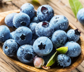 Blueberries in the wooden bowl on the table.