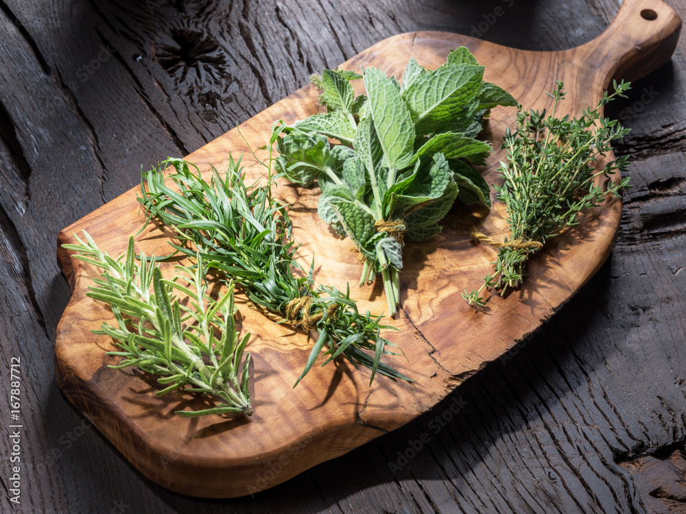 Wall mural Fresh herbs on the wooden table.