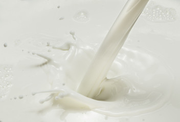 Pouring milk and milk splash. Close-up.