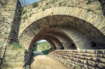 View of the arcs of the old historic stone bridge