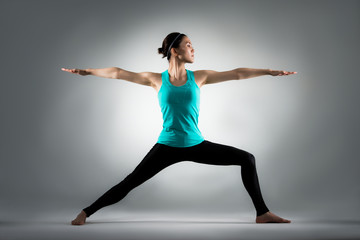 fitness teacher doing yoga in grey background
