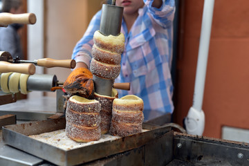 A girl bakes sweet bread (Trdelnik) in UNESCO World Heritage town, Cesky Krumlov, Czech Republic