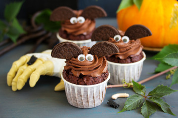 Chocolate muffins, with a chocolate cream in the form of bat on Halloween.