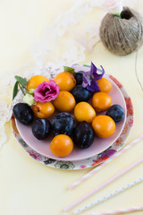 Plums and apricots on a pink plate